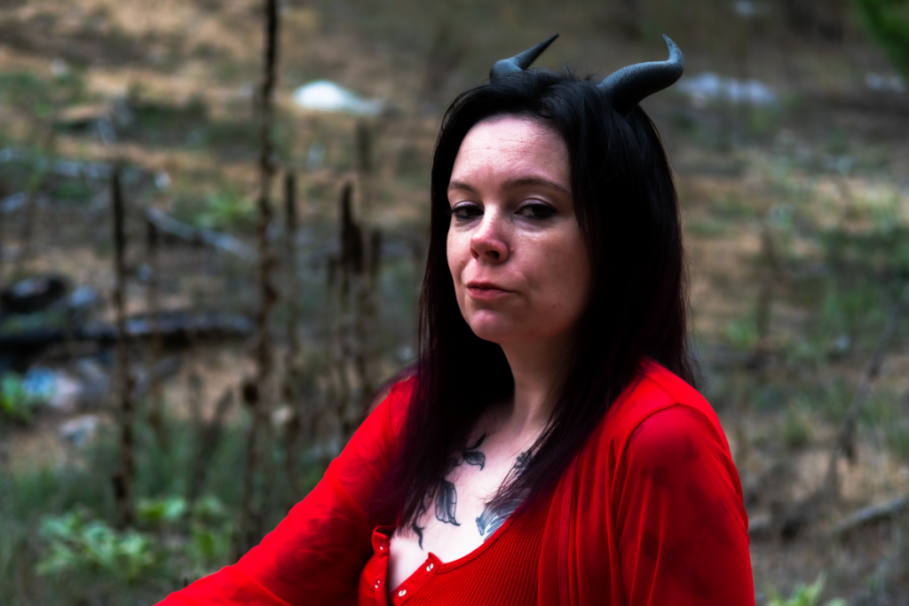 Woman with demon horns and red outfit.